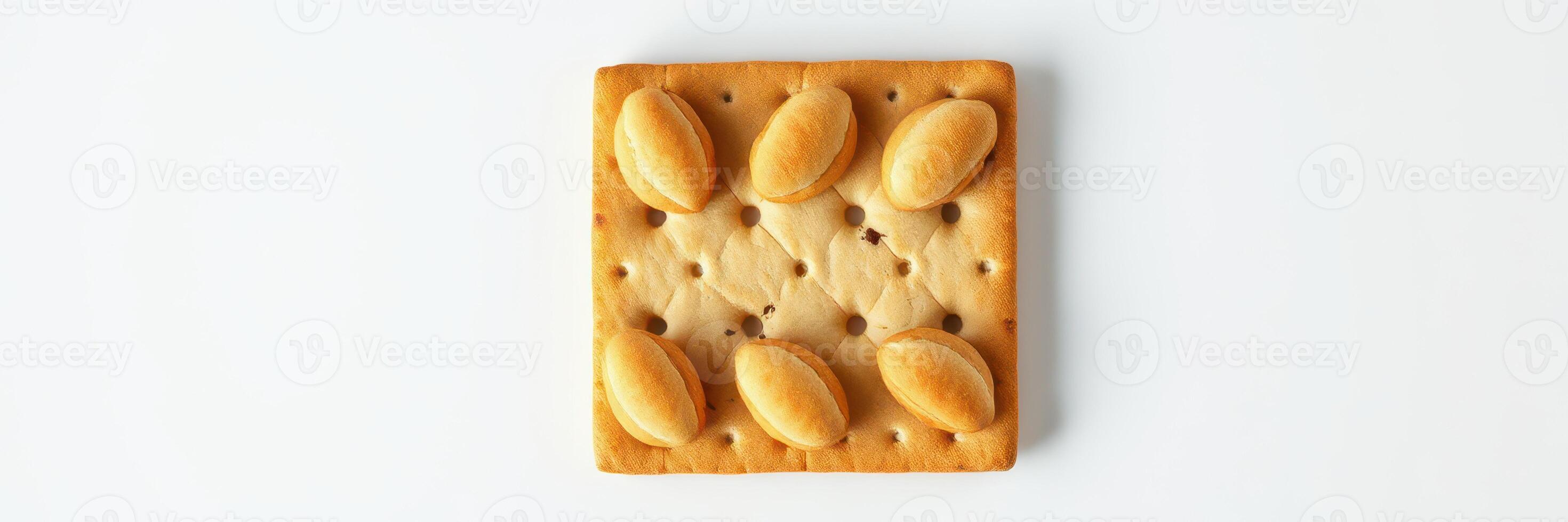 Unique square cookie with an intricate design featuring oval shapes at each corner positioned on a white background photo