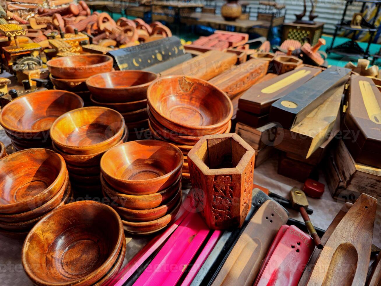 Beautiful Wooden Crafts a variety of polished wooden bowls, trays, coasters, and other handcrafted items. The intricate patterns carved into the wood highlight the skill of the artisans. photo