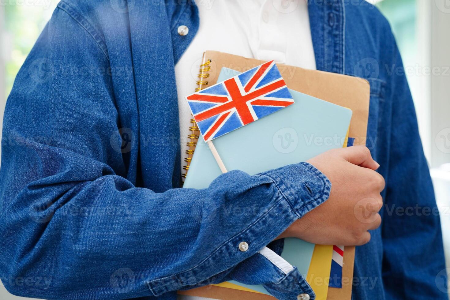 Learn English language, Asian teenage student hold book with flag in course at school. photo