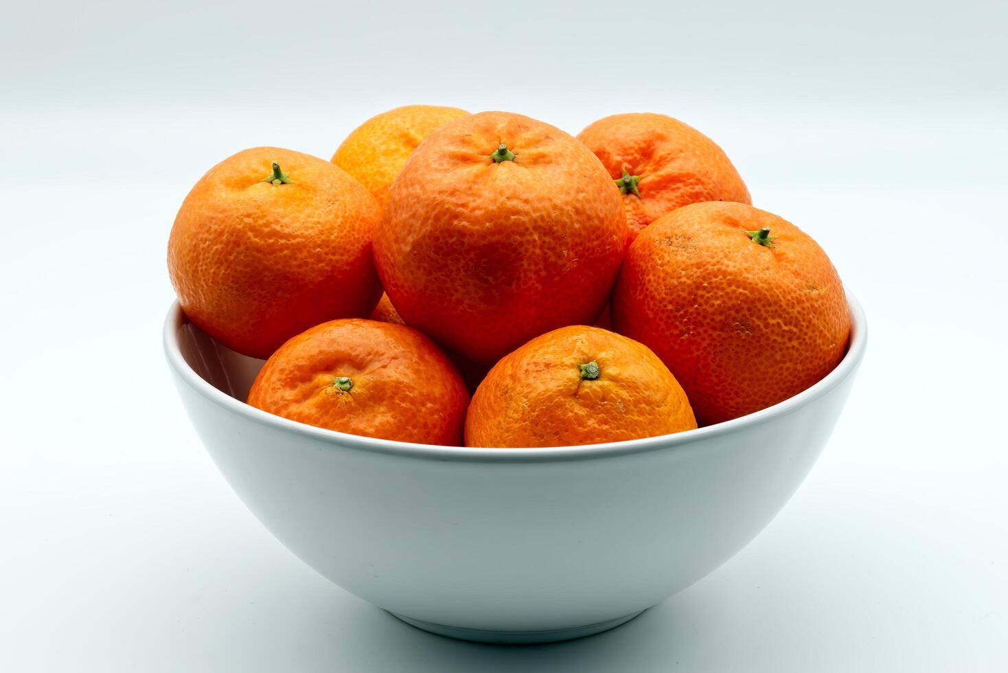 A close-up view of a bowl filled with juicy clementines. photo