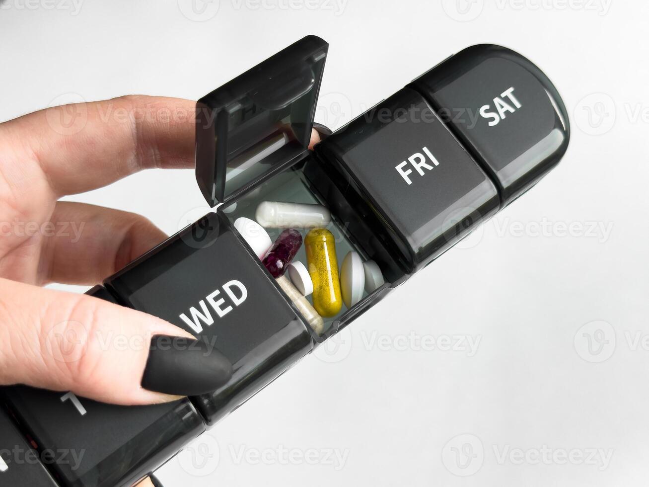 Weekly pill organizer with vitamins and supplements for daily health management photo