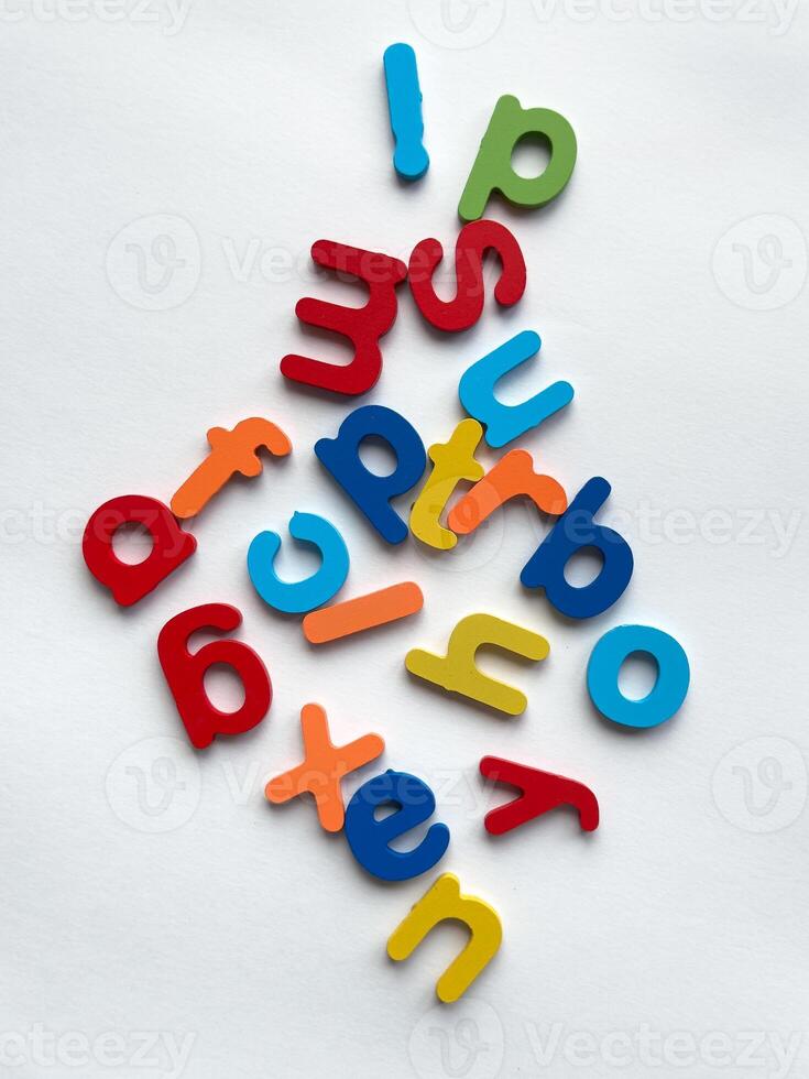 Colorful alphabet letters arranged in playful chaos on white background for educational design photo