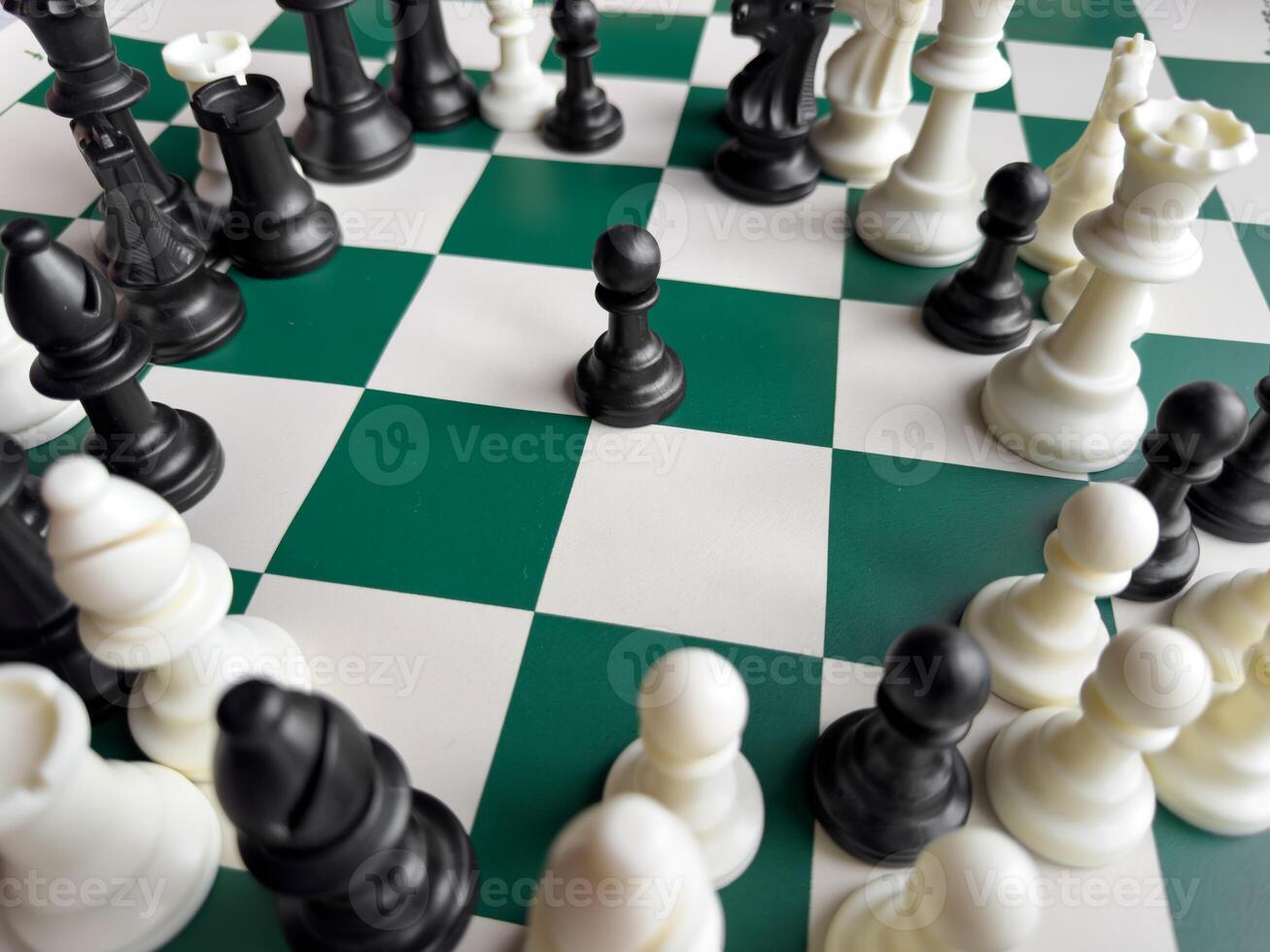 Strategic chessboard with black pawn surrounded by chess pieces photo