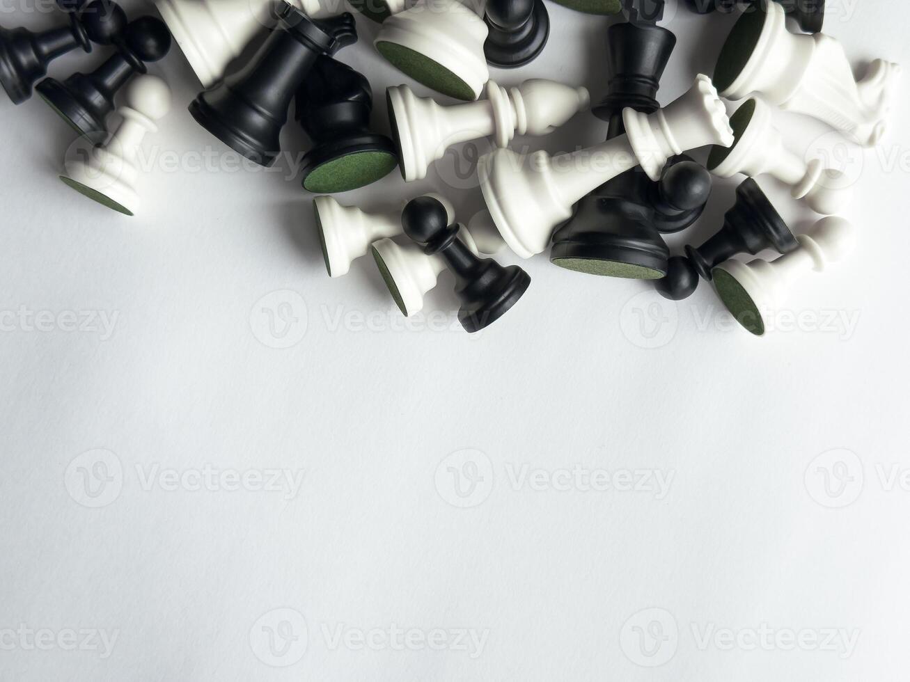 Collection of black and white chess pieces on a minimalist white background photo