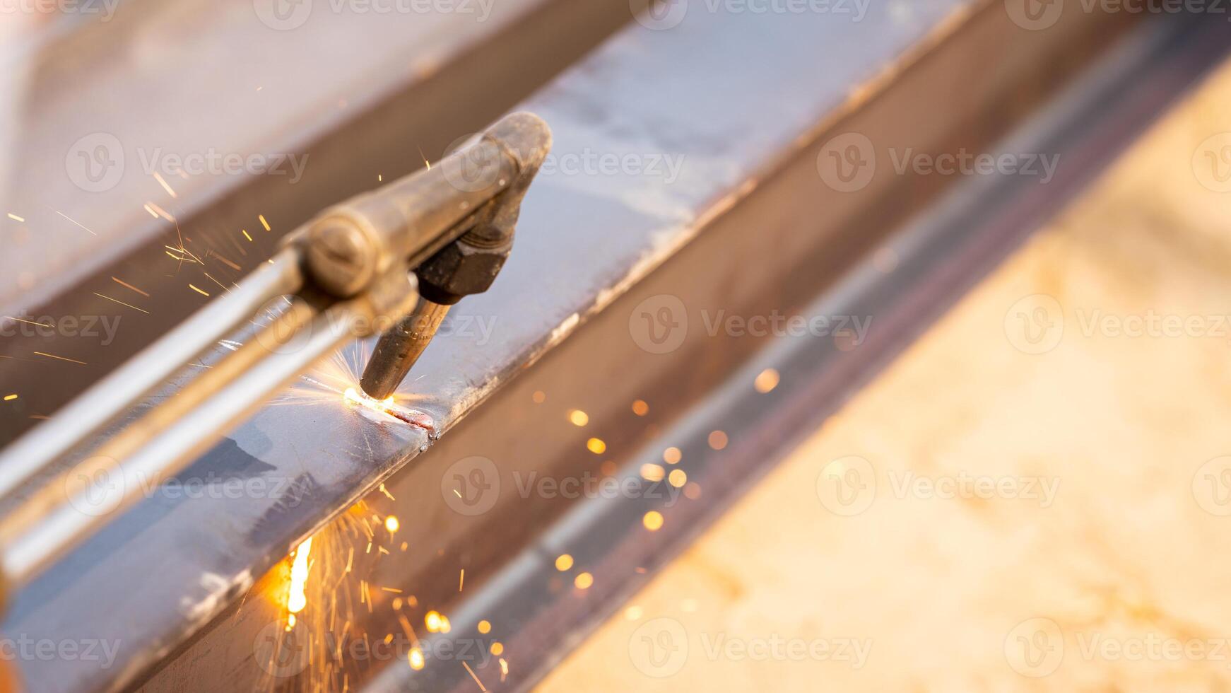 Skilled metalworker uses torch to cut through steel. Sparks fly as craftsman demonstrates precision in industrial workshop. Concept of balancing risk and expertise in dangerous metalworking processes. photo