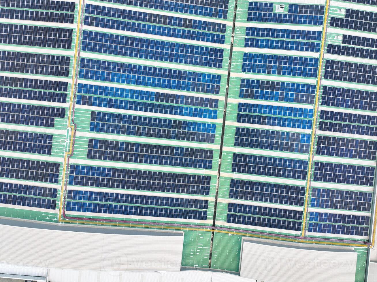 Solar energy system installed on the rooftop of an industrial factory and warehouse. Clean and renewable power solutions, green energy innovation, and sustainable commercial electricity generation. photo