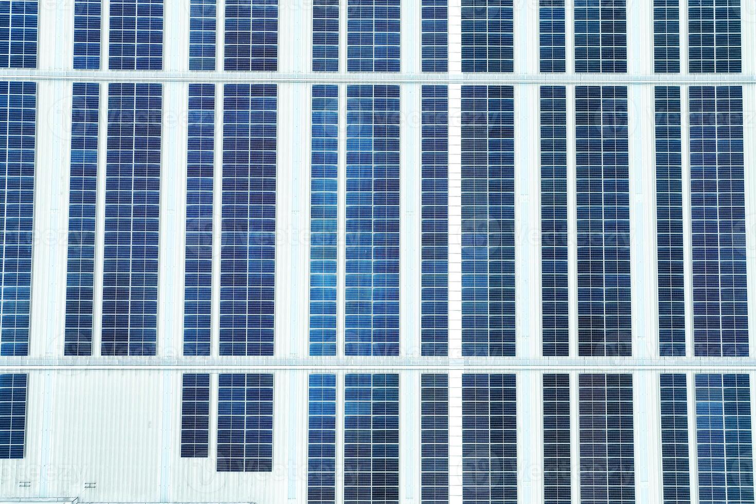 Solar energy for factory and warehouse building. Solar panels on roof of industrial plant. Commercial solar power. Rooftop solar power. Rooftop renewable energy system. Sustainable green energy. photo