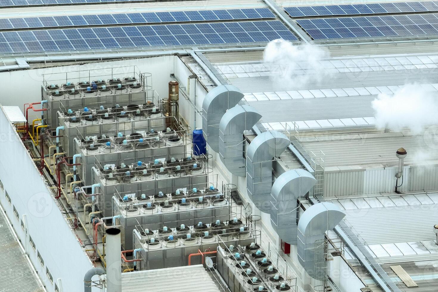 Sustainable industrial rooftop. Aerial view showcasing solar panels, ventilation systems, and industrial chillers. Renewable energy and efficient cooling in modern manufacturing facilities. photo