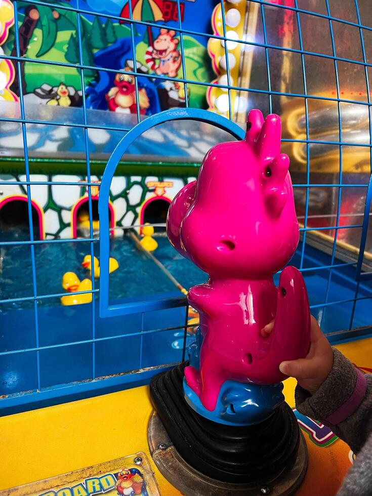 Colorful arcade game with rubber ducks and bright pink controls photo