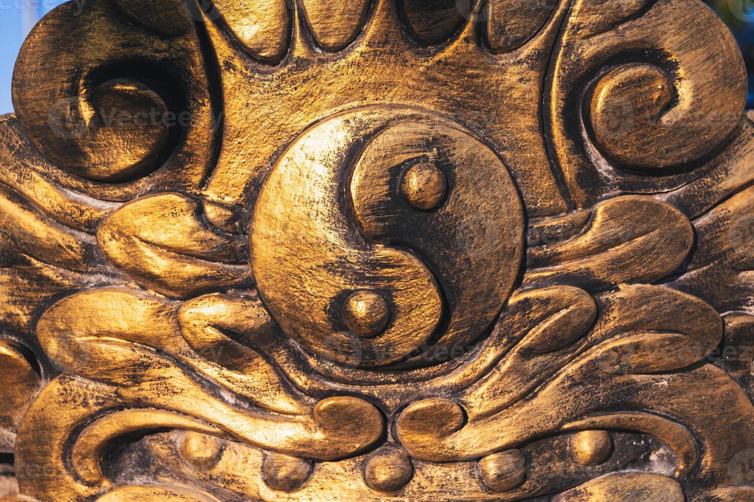 The golden Yin-Yang symbol on the temple wall photo