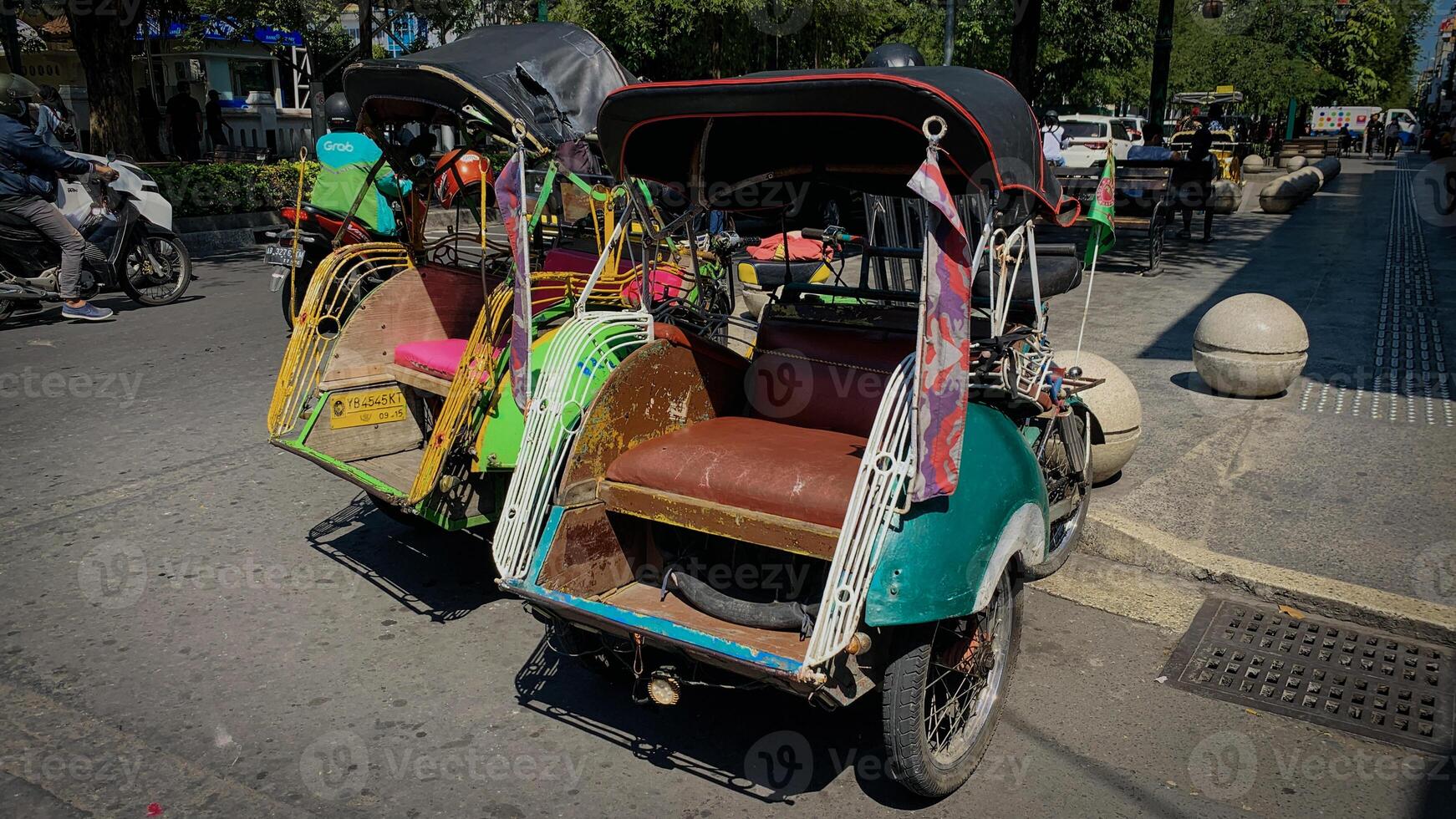 Pedicab Parked on Urban Street in Bright Daylight, pedicab or rickshaw or locals calls it becak with a canopy is parked on a sunny street, reflecting a vibrant urban scene photo