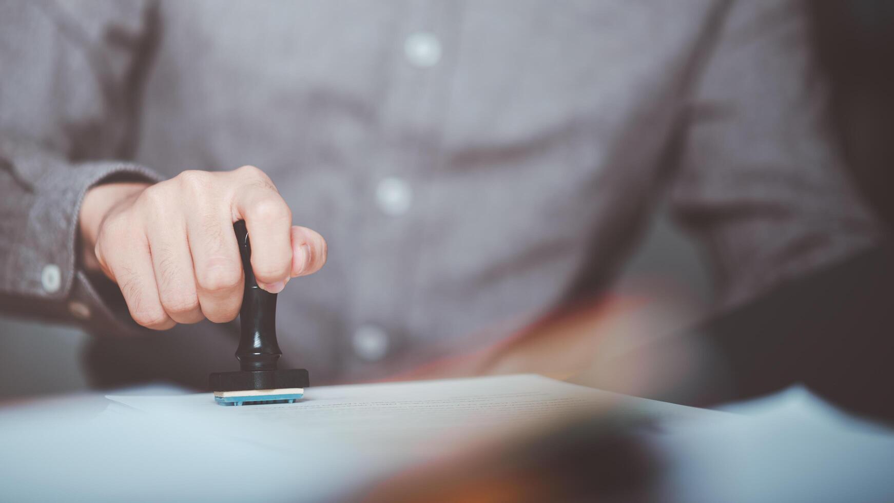 Businessman validates and manages business documents and agreements, signing a business contract approval of contract documents confirmation or warranty certificate,approval stamp photo