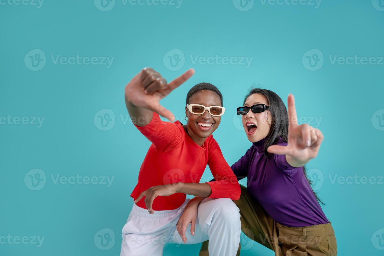 Young afro american and chinese woman over isolated background smiling making frame with hands photo