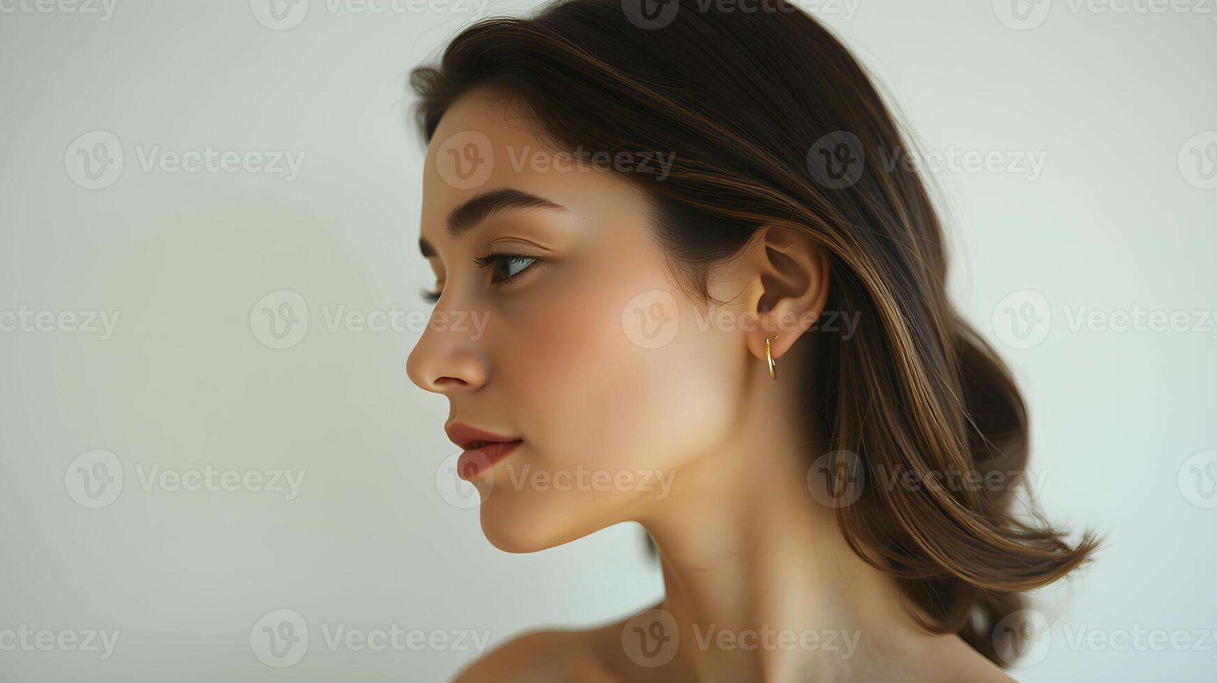 Elegant side profile of a woman showcasing a luminous complexion against a neutral backdrop photo