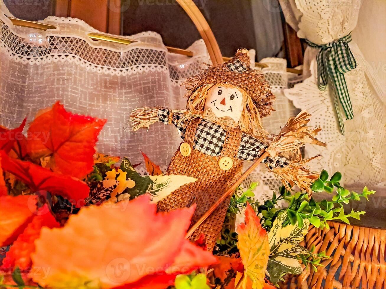 autumn composition with a small scarecrow standing on the window photo
