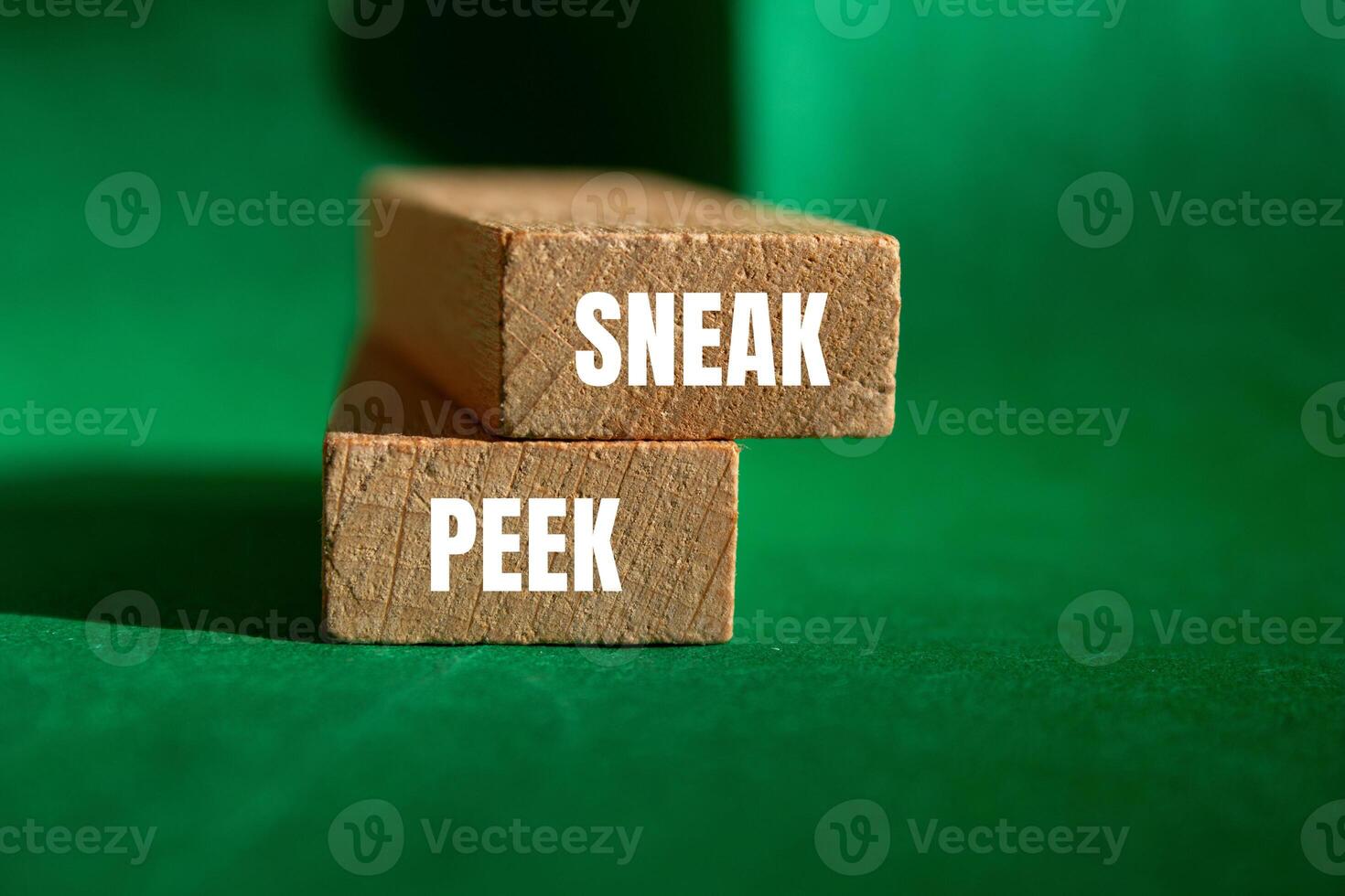 Sneak peek message written on wooden blocks with green background. Conceptual sneak peek symbol. Copy space. photo