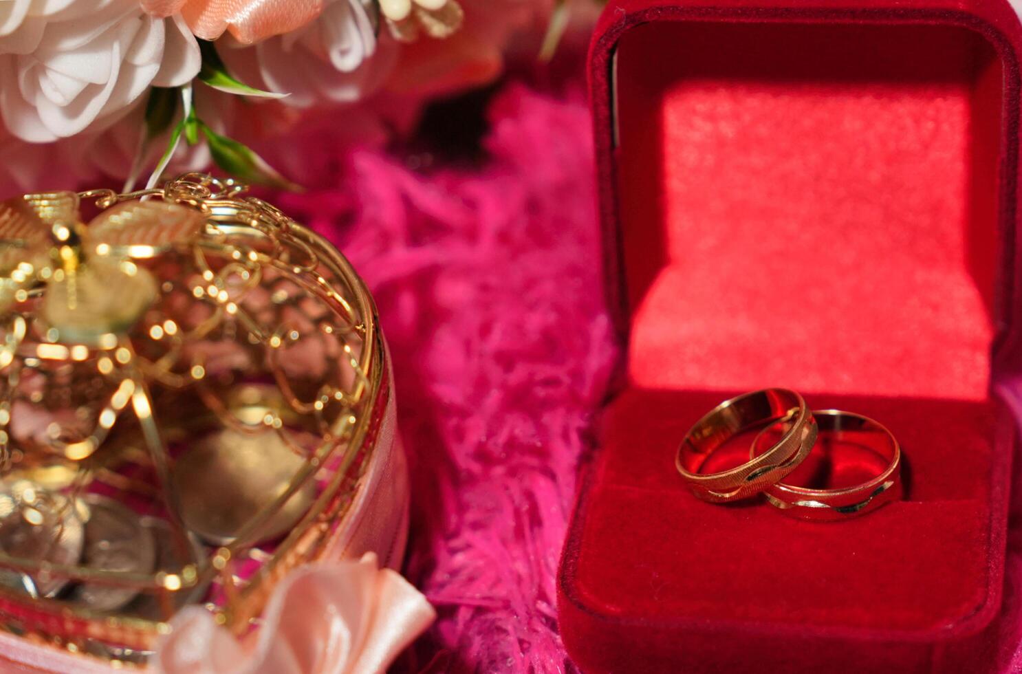 two gold wedding rings in a red box with a heart photo