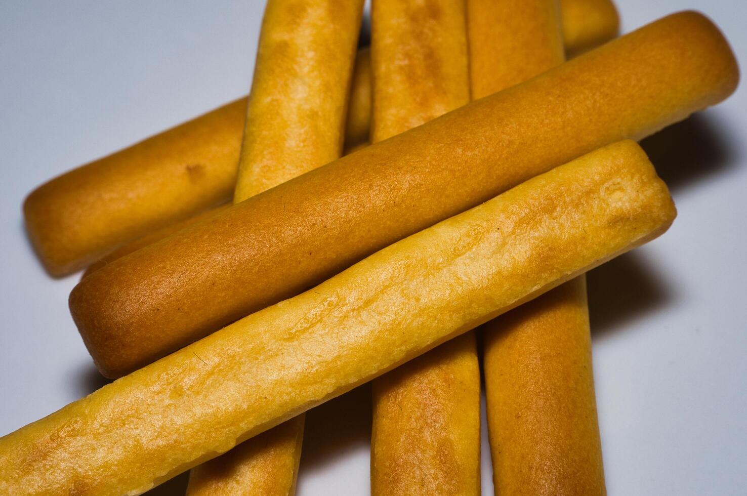 a pile of bread sticks on a white surface photo