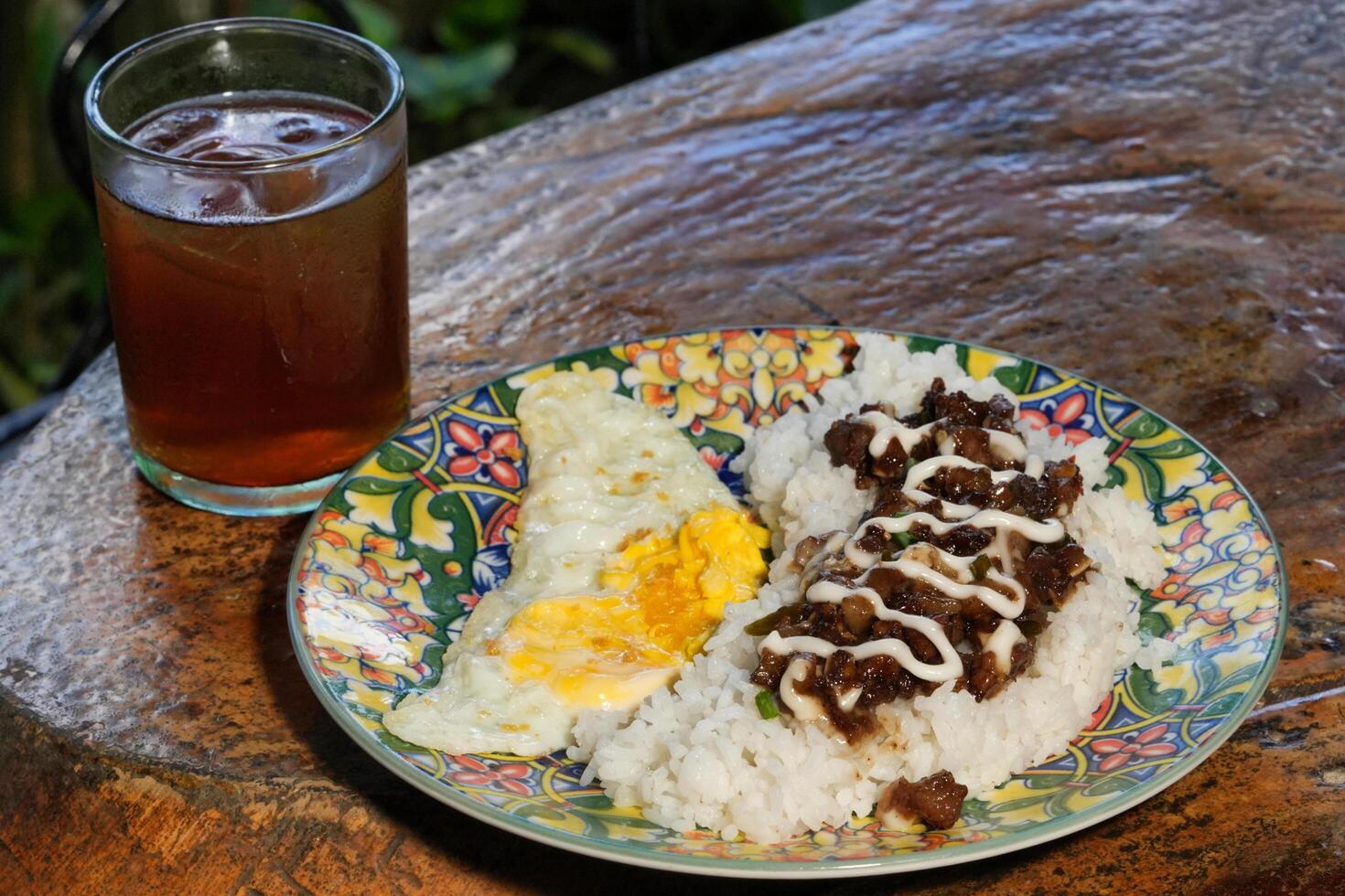 a plate of food with rice and an egg on it photo