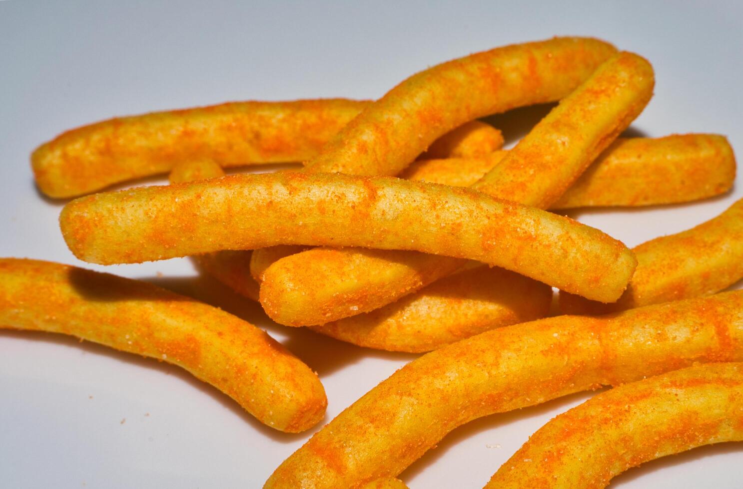 a pile of cheese flavored snacks on a white plate photo