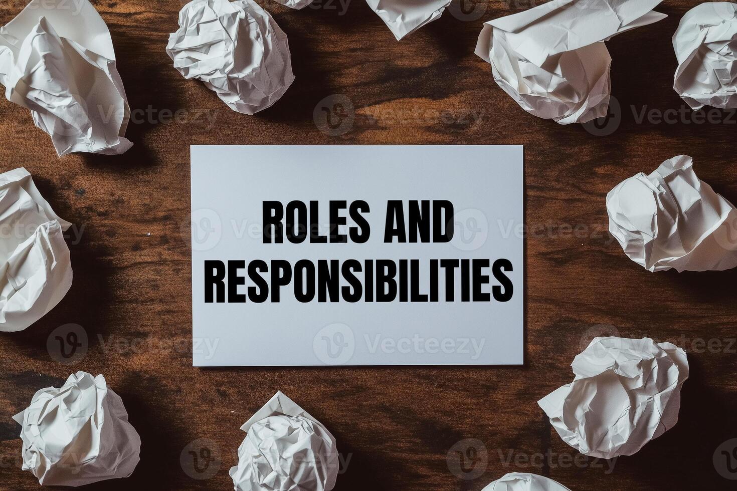 Roles and responsibilities message written on white card with crumpled paper balls. Conceptual roles and responsibilities symbol. photo