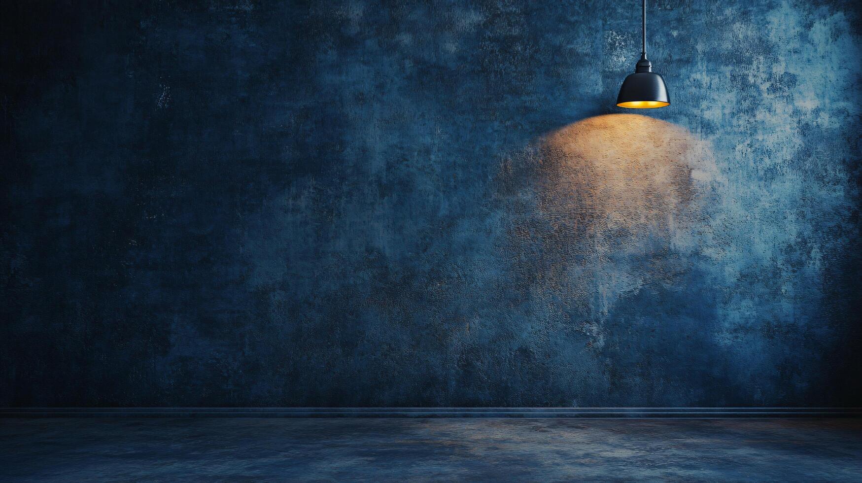 Light shining on a wall with a blue background. The light is on a lamp that is hanging from the ceiling. The room is empty and the light is the only thing that is visible photo