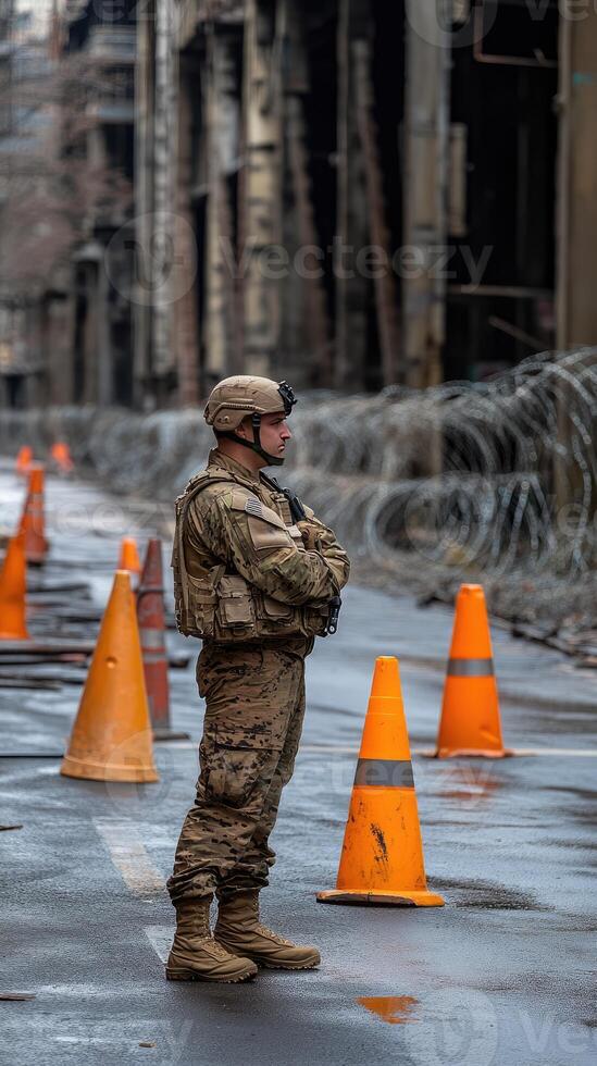 A soldier stands in front of orange cones photo