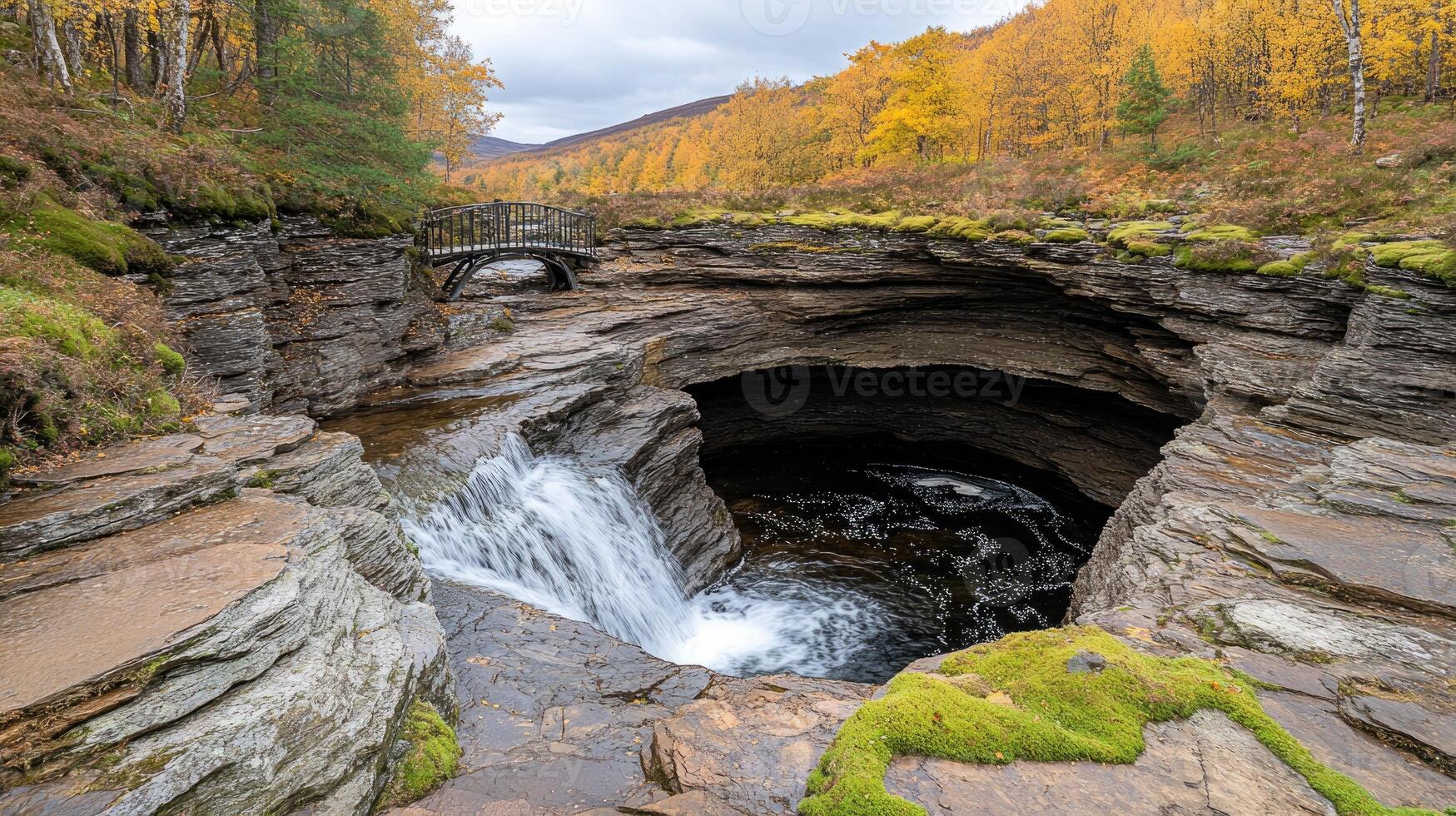 A waterfall is flowing into a cave in the woods photo
