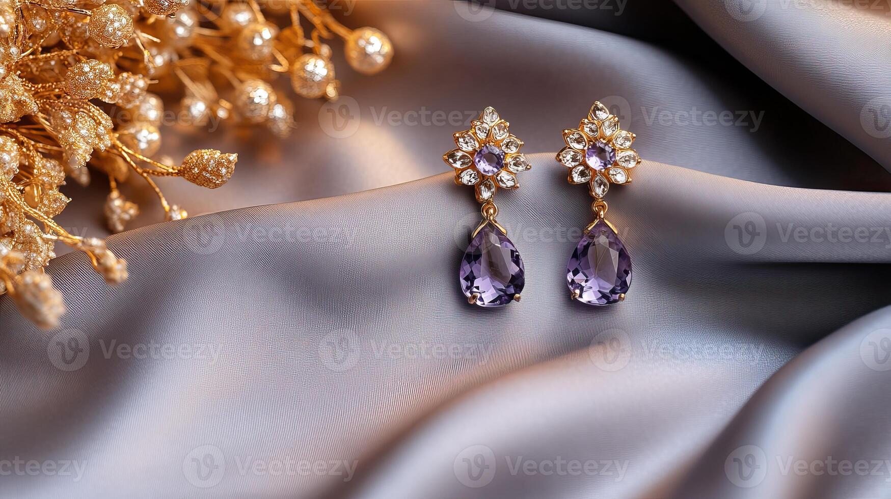 Purple and gold earrings on a silk fabric photo
