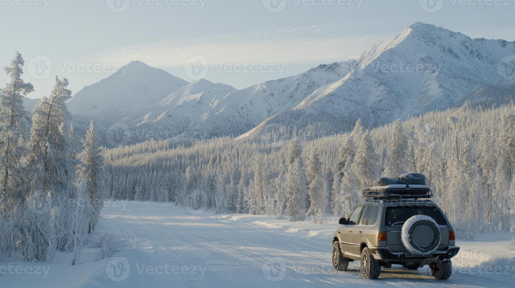 A car driving down a snowy road with mountains in the background photo