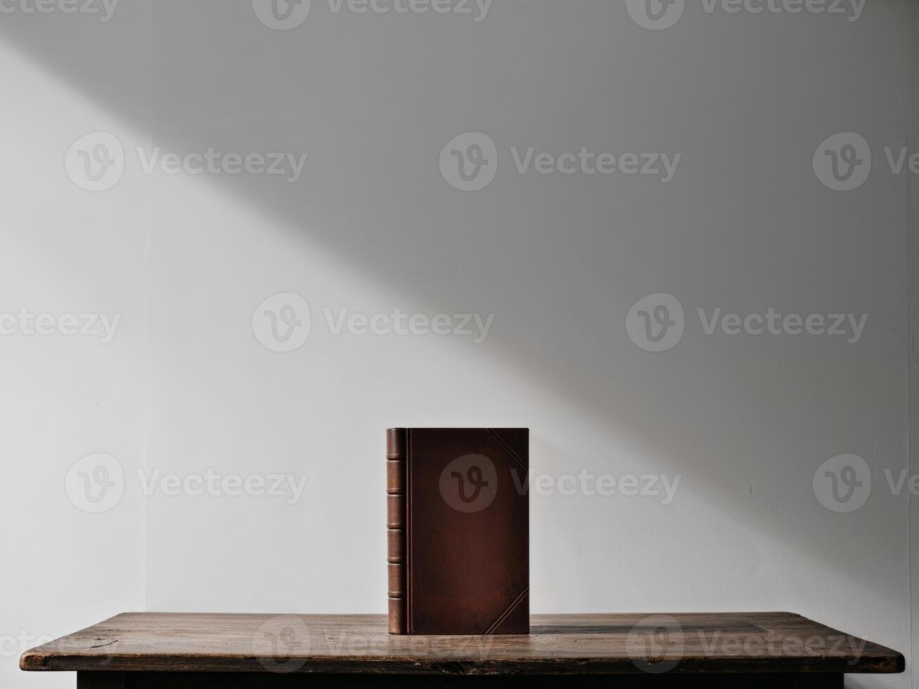 A book is sitting on a table in front of a wall. photo