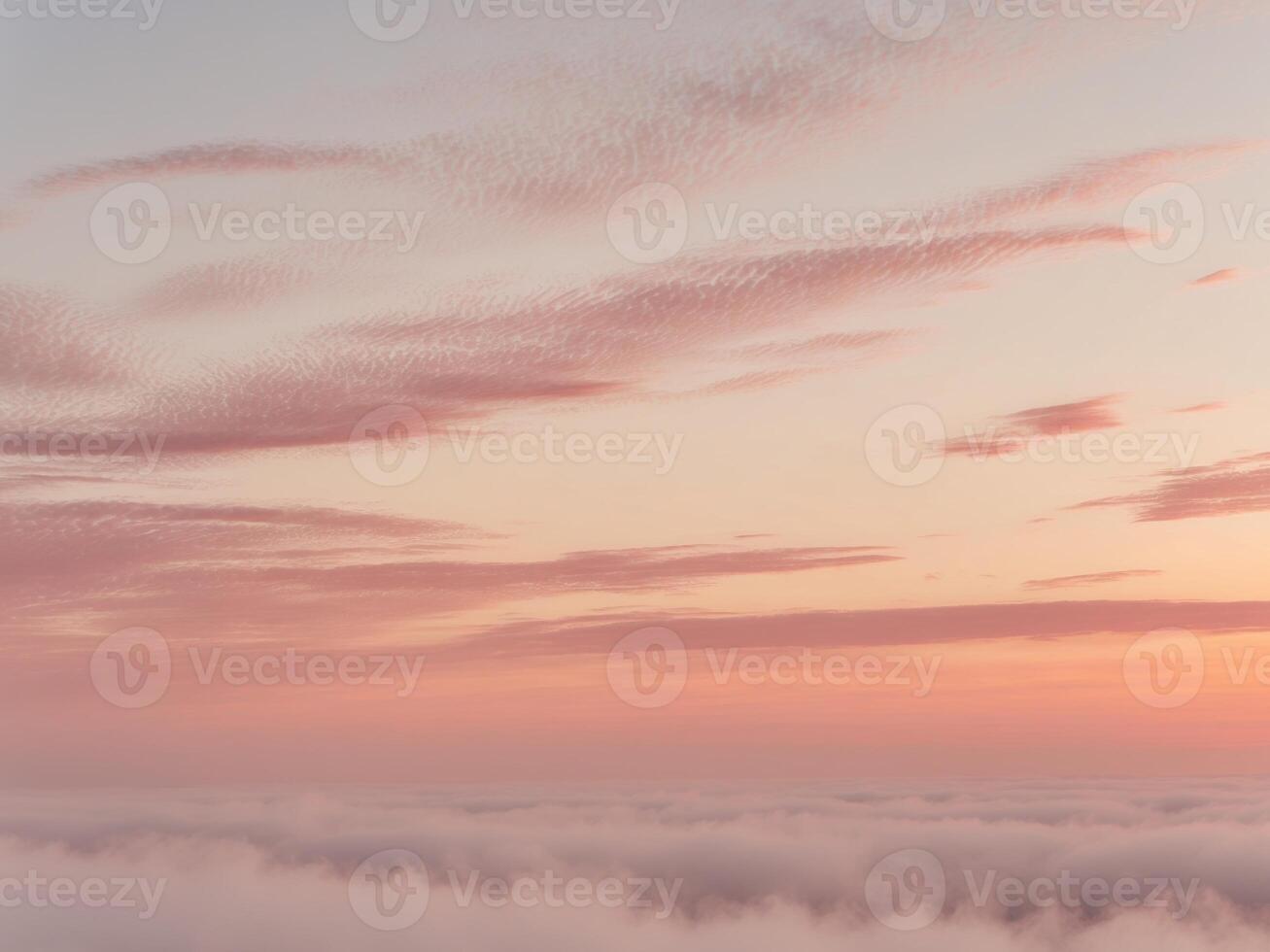 A plane flying over the clouds at sunset photo