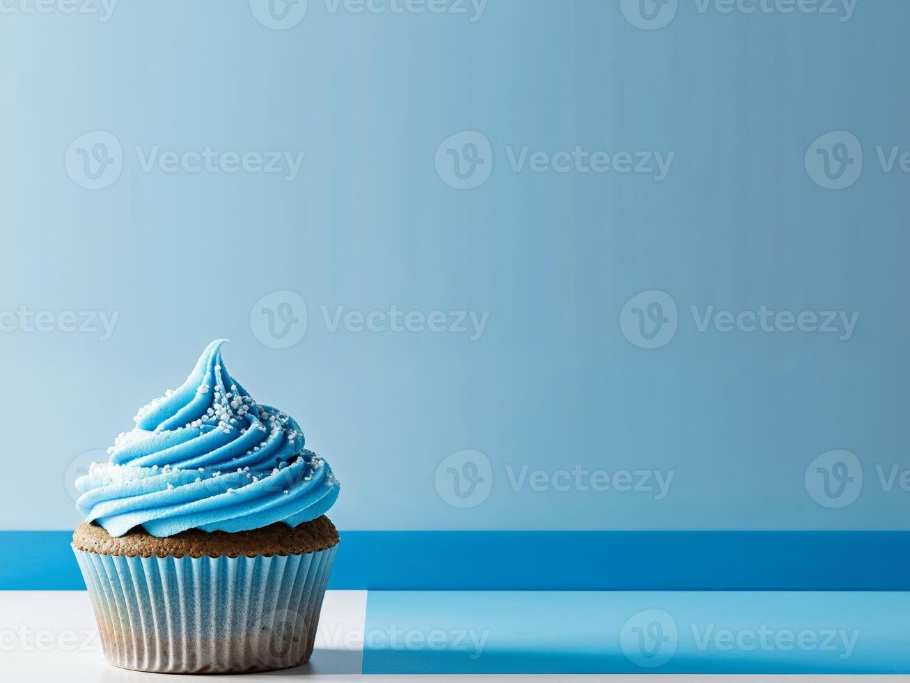A cupcake with blue frosting and sprinkles on a blue background photo