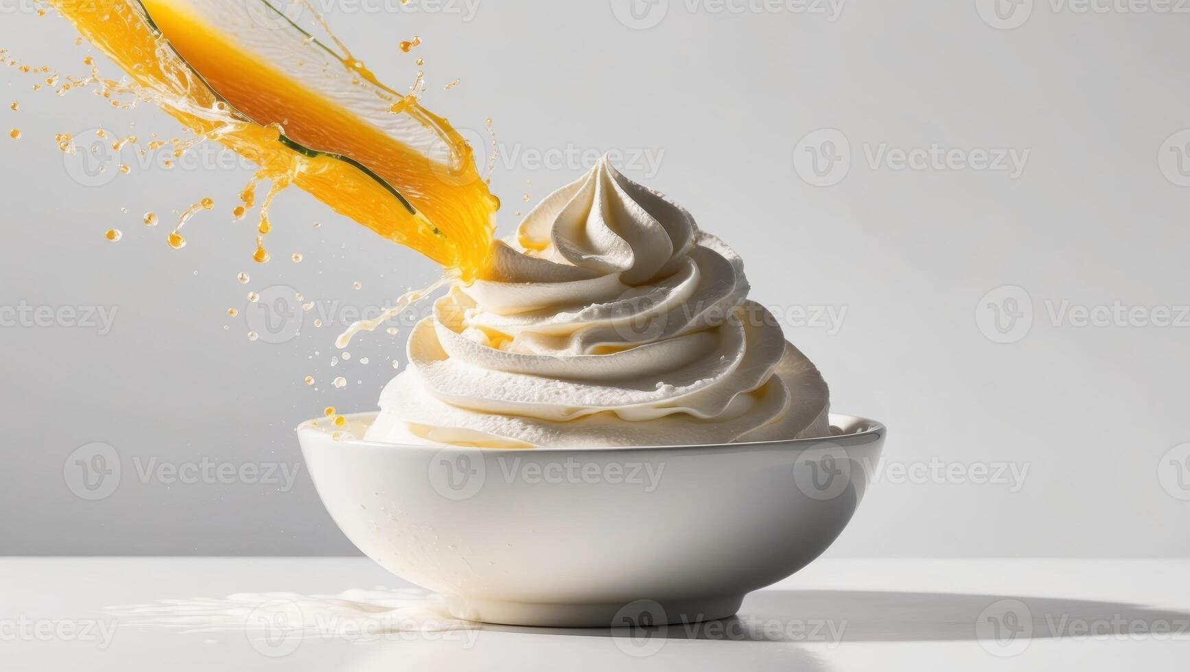 A bowl of whipped cream and orange juice splashing out of it photo