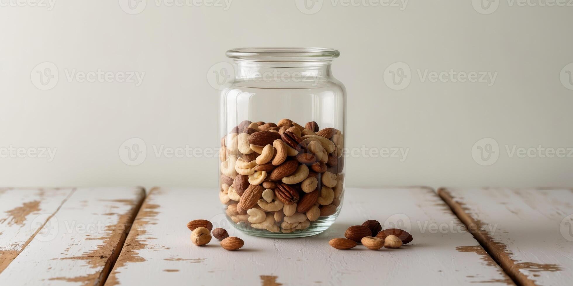 A glass jar filled with nuts on a wooden table photo