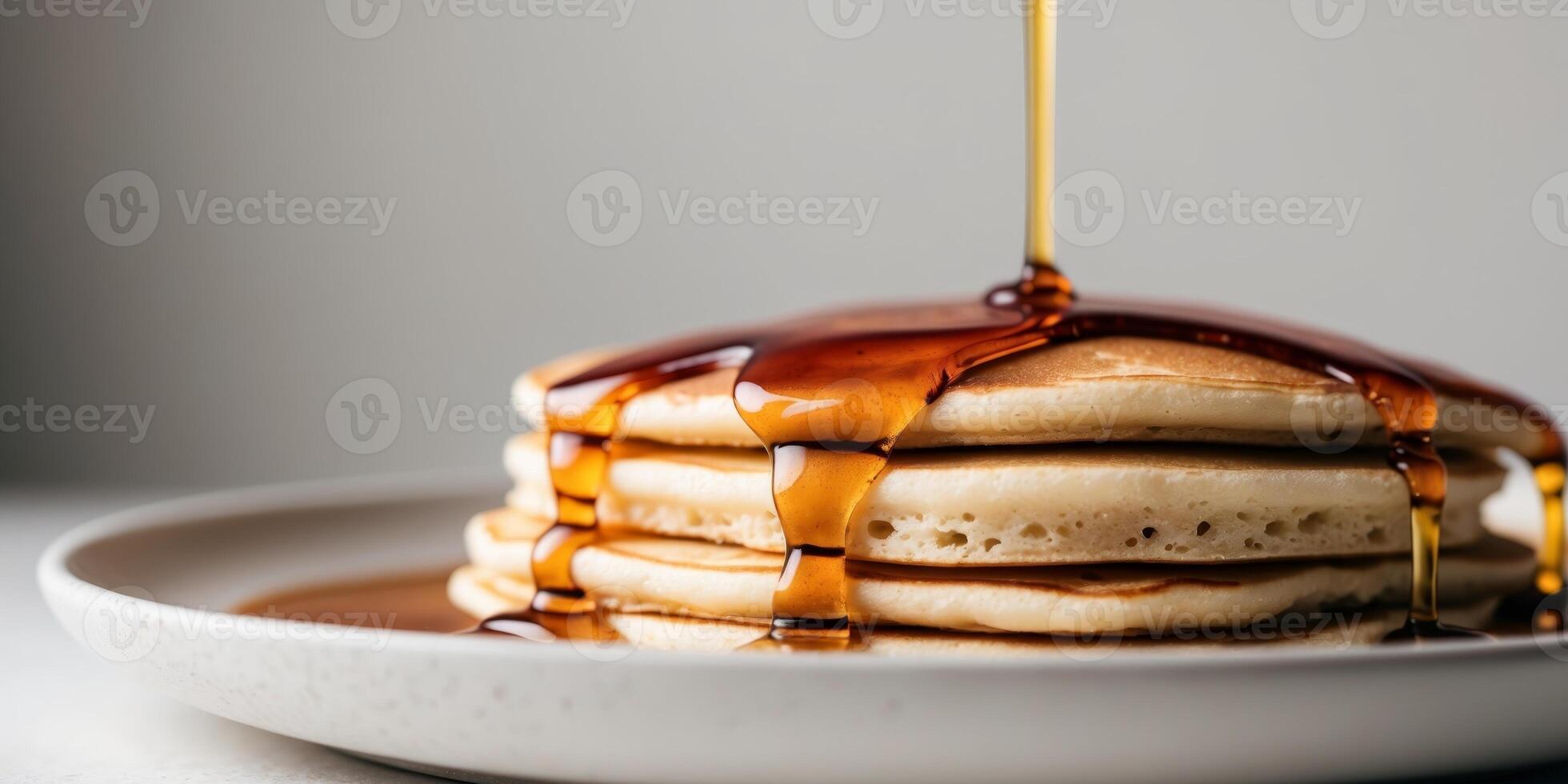 A stack of pancakes is being drizzled with syrup photo