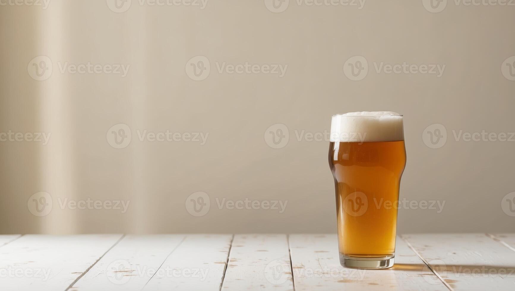 A glass of beer sitting on top of a wooden table photo