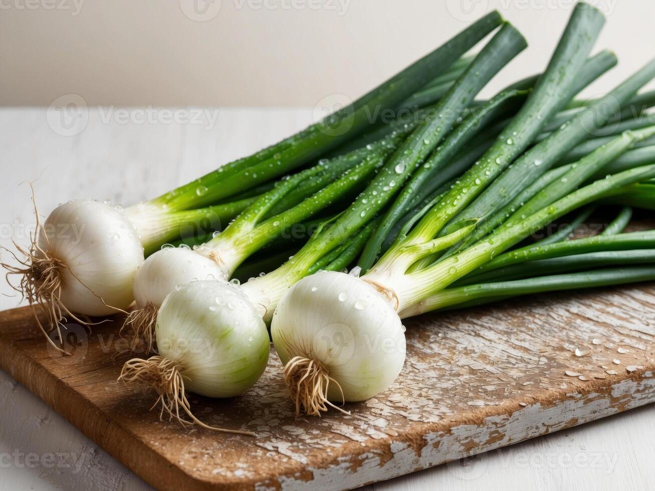 Fresh spring onions with roots dew drops on wooden board farm to table concept photo