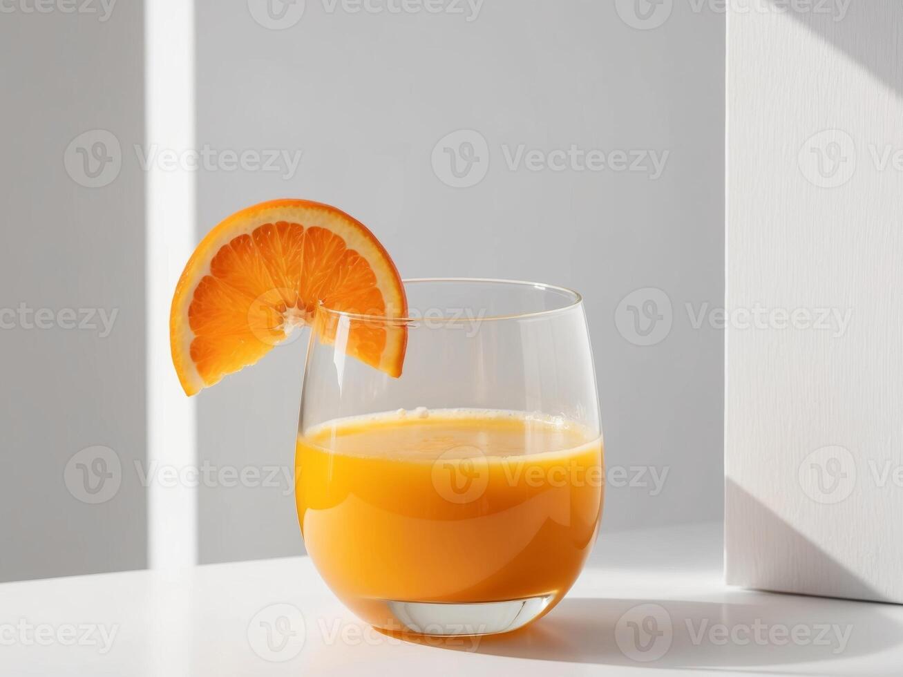 A glass of orange juice with a slice of orange in it photo
