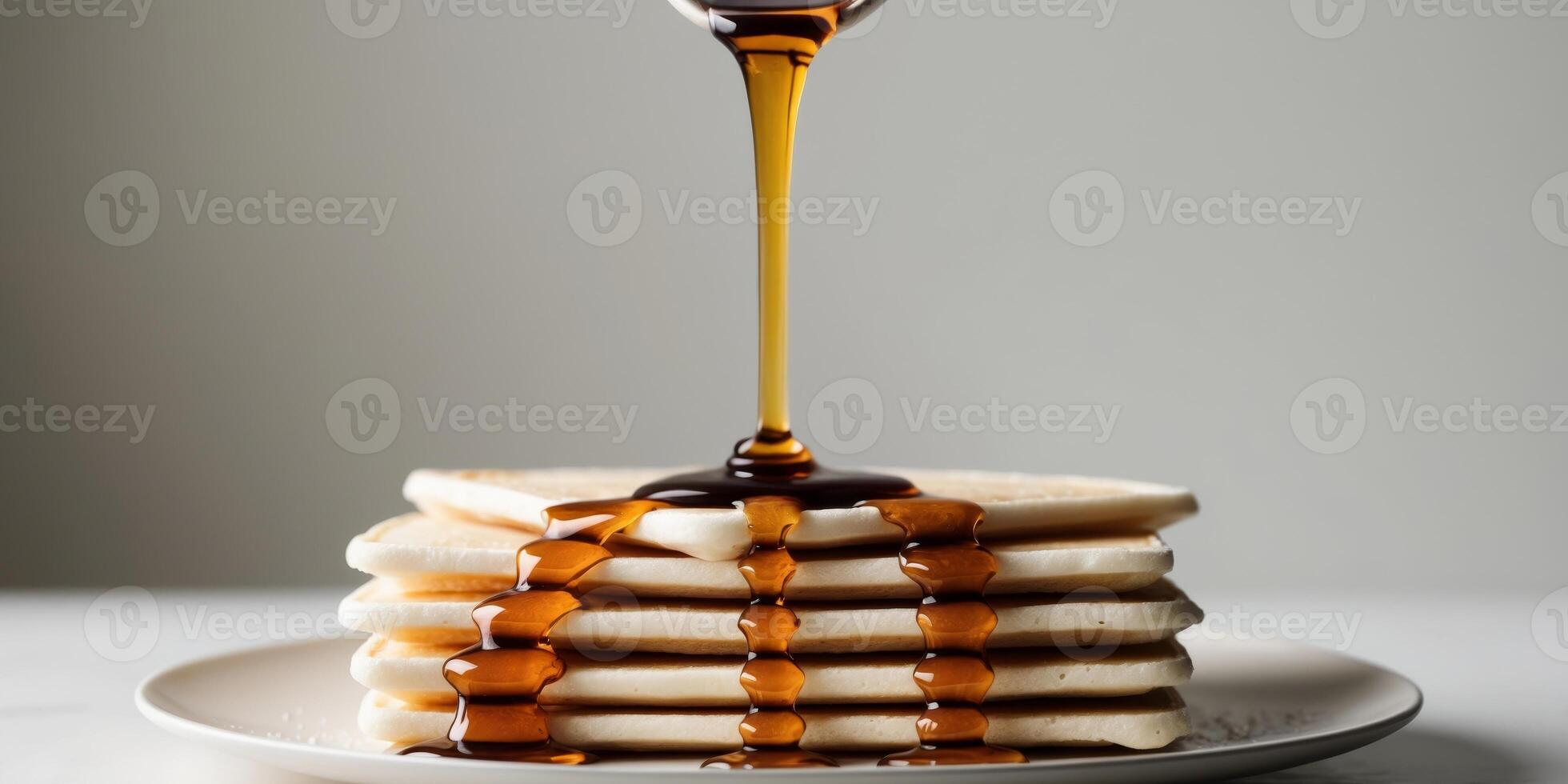 A stack of pancakes with syrup being poured over them photo
