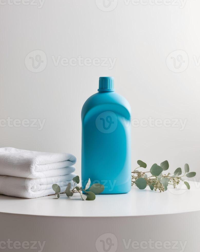 Blue plastic detergent bottle mockup standing on white surface with clean towels and eucalyptus branches photo