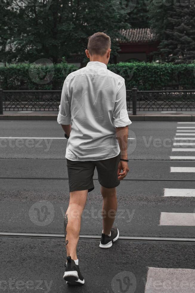 A man crossing the street in casual attire, embodying a sense of style and freedom photo
