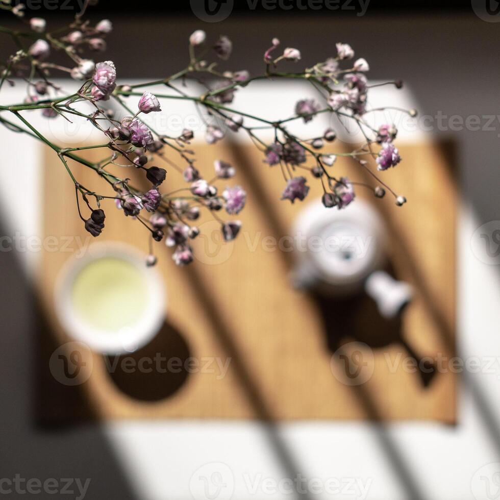 An Elegant Tea Setup Surrounded by Flowers and Gentle Shadows Enhancing the Aesthetic photo