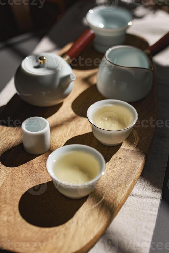 An Elegant Tea Set Displayed on a Gorgeous Wooden Tray Accentuated by Soft Shadows photo