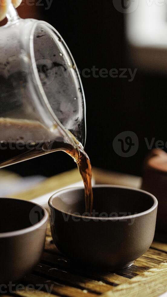 Pouring tea into elegant and beautifully designed cups set in a cozy and inviting environment photo