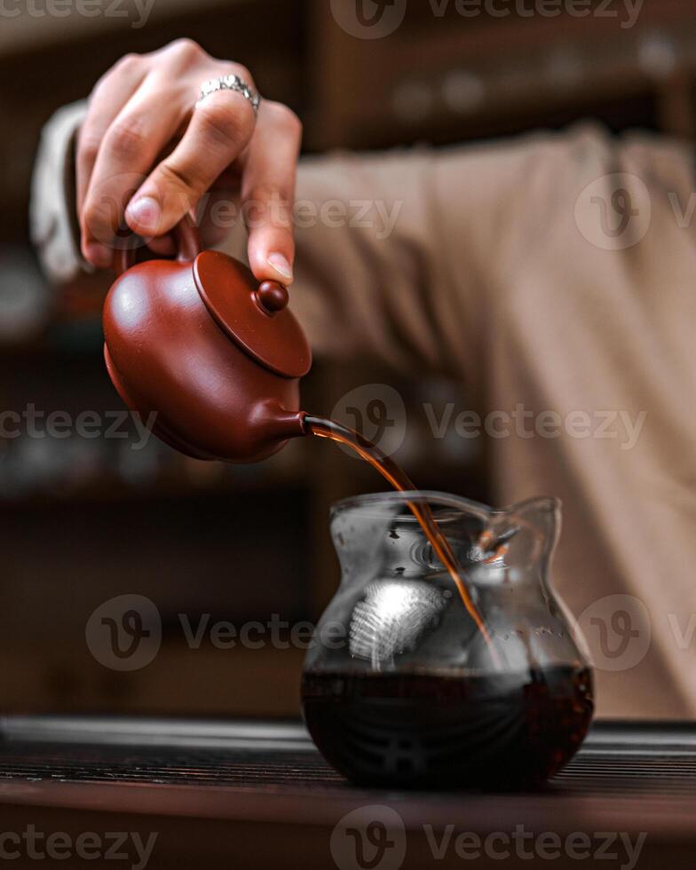 An Artisan Teapot Elegantly Pouring into a Glass Carafe, Creating a Captivating Experience photo