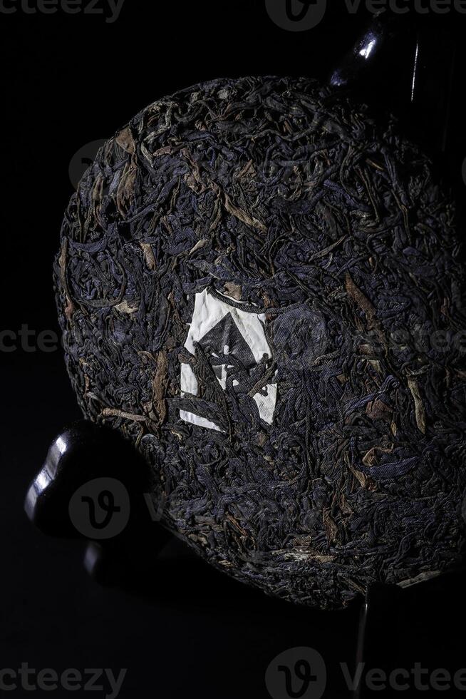 A closeup image of a uniquely compressed tea cake against a dark background enhances its features photo