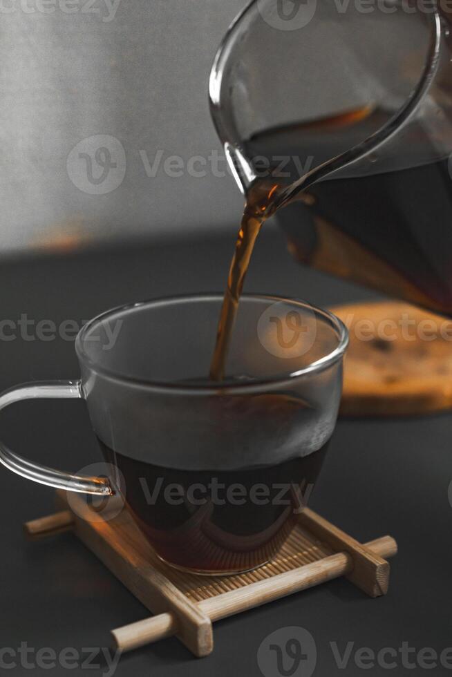 Pouring Freshly Brewed Coffee into a Clear Glass Cup with an Inviting Aroma and Appeal photo