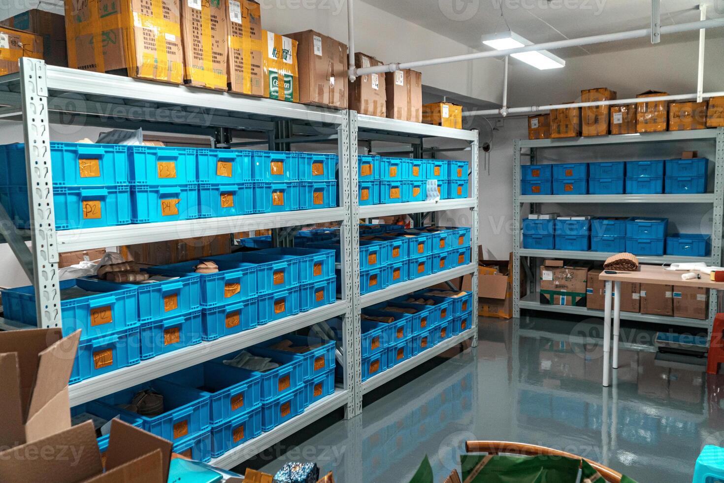 This is a wellorganized storage room that features blue bins and shelves for efficiency photo