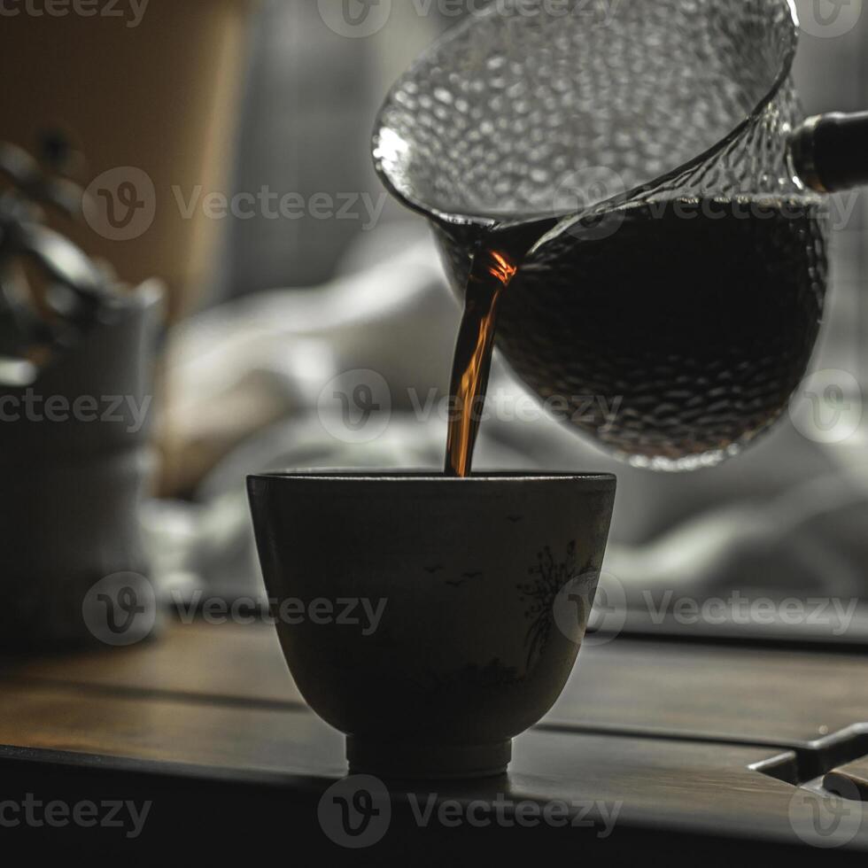 Pouring steaming coffee into a rustic ceramic cup is a delightful and comforting experience photo